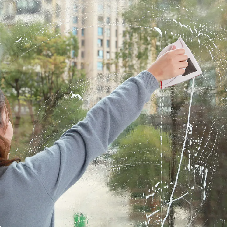 Person cleaning a window with a squeegee